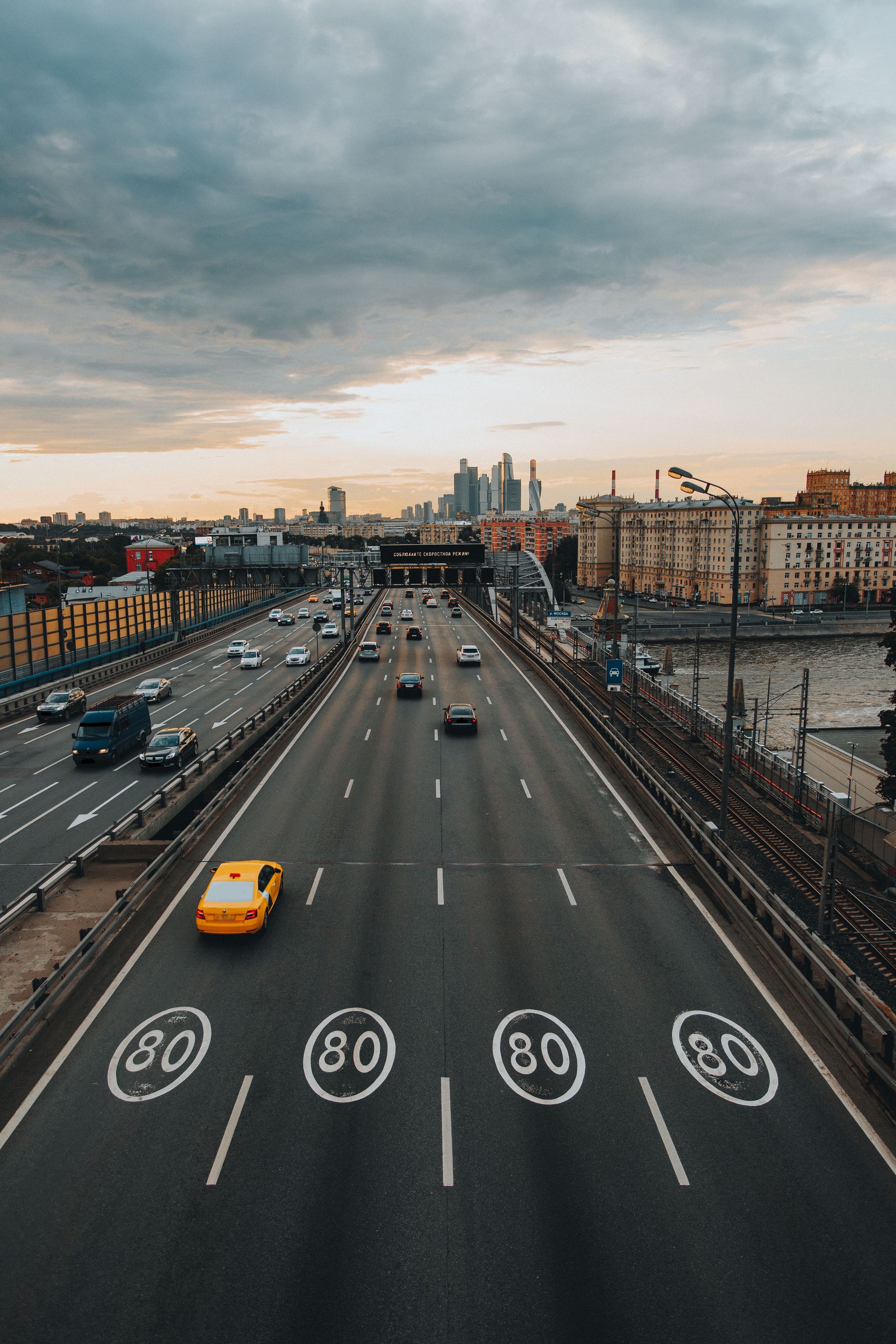 A stunning aerial view of a city highway with vehicles at sunset, showcasing urban life.